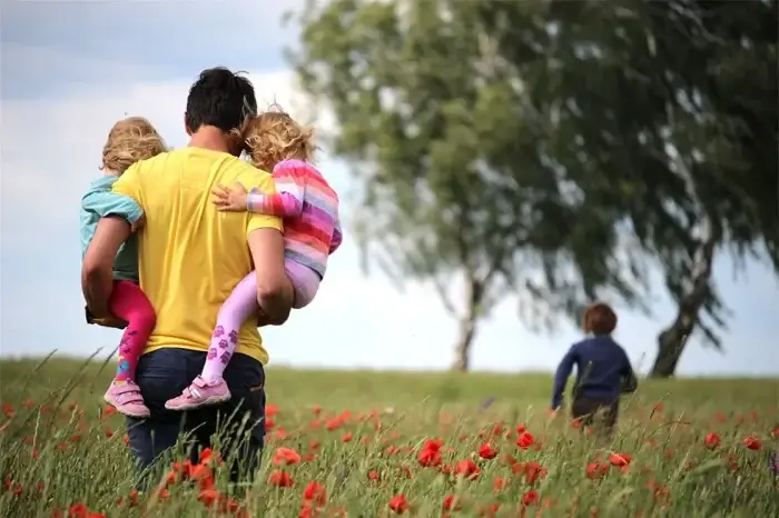 Vater mit Kindern im Blumenfeld