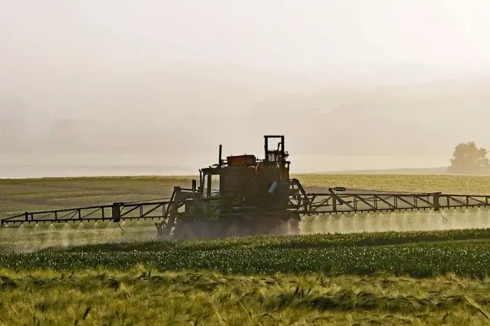 Erntemaschine faehrt ueber ein Feld