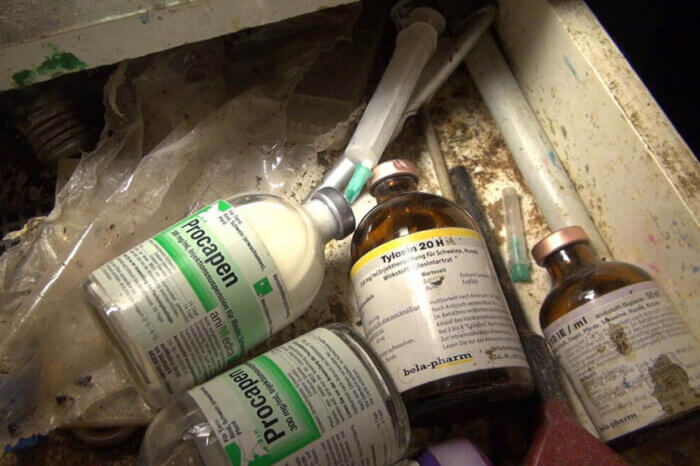 Glasflaschen mit Antibiotika in einer dreckigen Schublade.