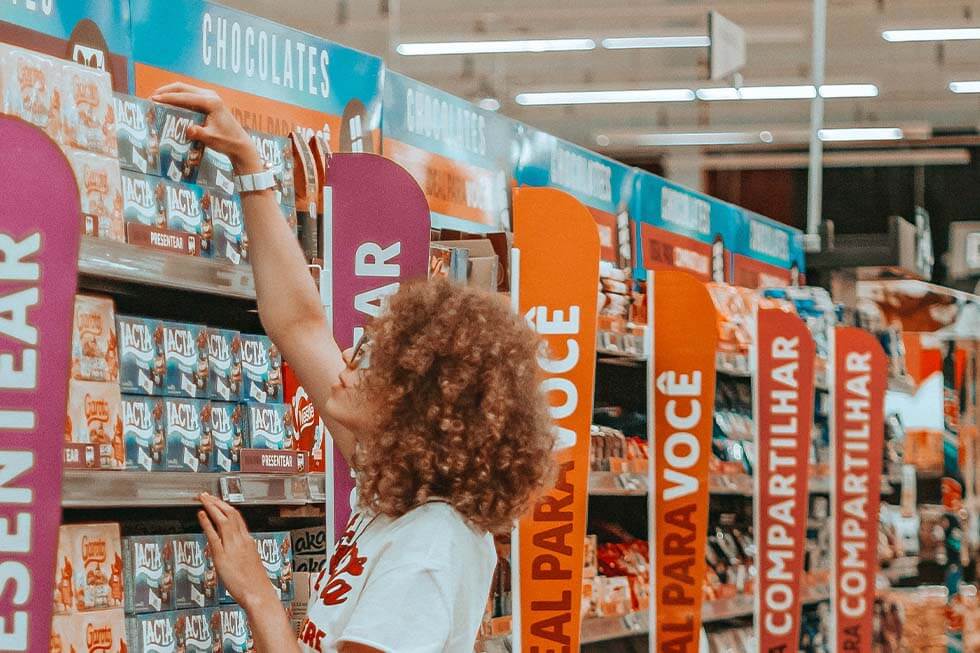 Eine Frau steht am Regal im Supermarkt.